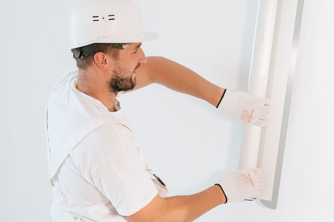 Professional worker installing drywall