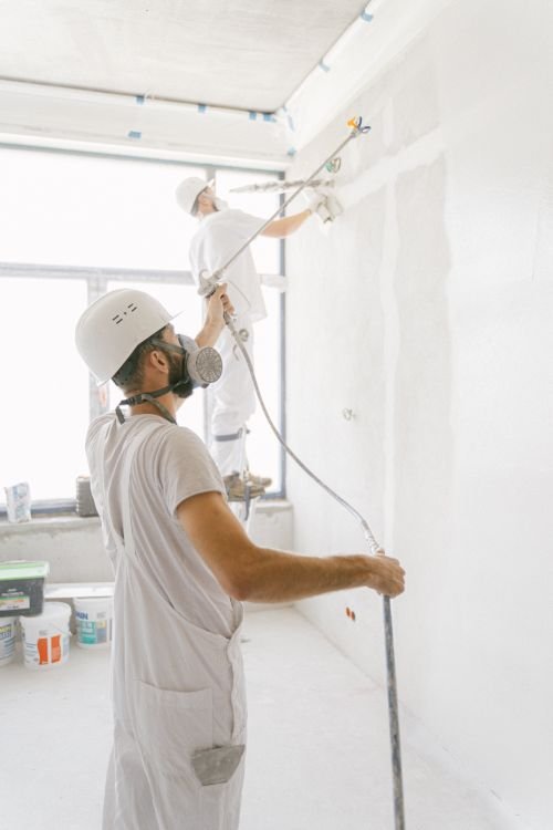 Professional painters spray painting a commercial interior